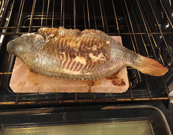 Delicious whole fish grilled on cooking salt plank